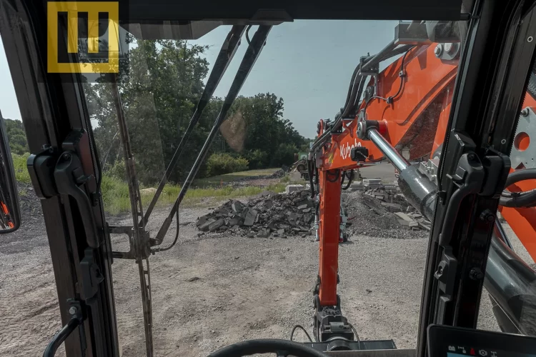 Koparka kołowa Kubota KW095 widok z kabiny na przód maszyny i co przednią