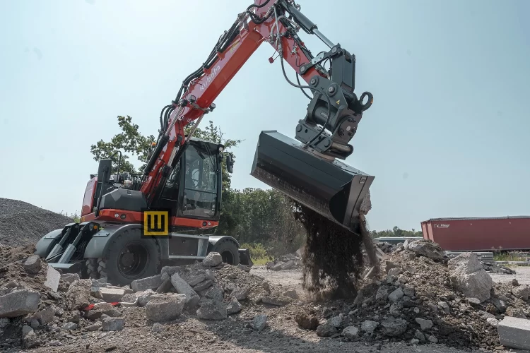 Koparka kołowa Kubota KW095 wysypująca gruz osprzętem