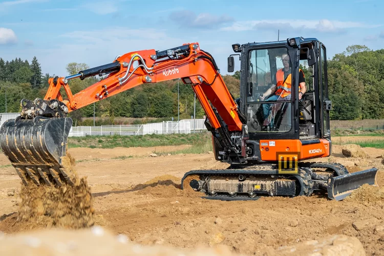 Minikoparka gąsienicowa Kubota KX042-5 praca w terenie koparka wysypuje piasek