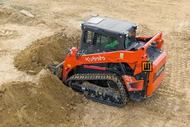 Ładowarka gąsienicowa Kubota SVL75-3 nabierająca piach łyżką