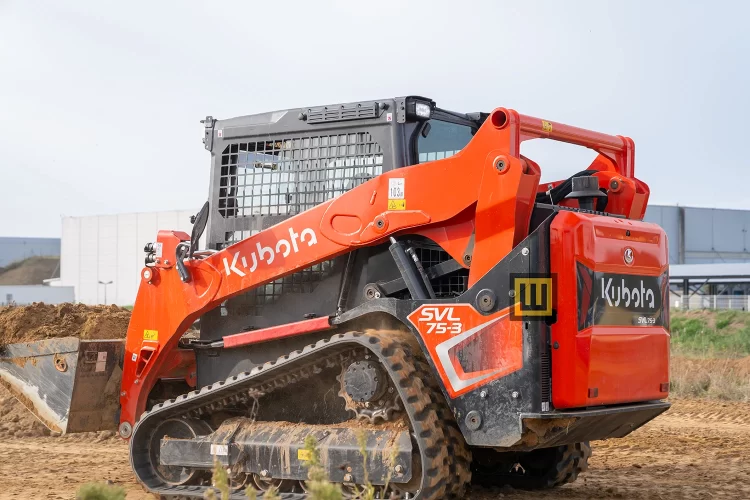 Ładowarka gąsienicowa Kubota SVL75-3 widoczna z boku z logiem i modelem