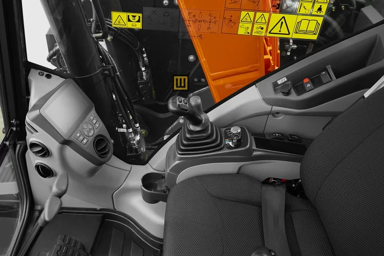 Koparka gąsienicowa Kubota U145 w kabinie operatora widoczny joystick różne dźwignie panel sterowania kamery