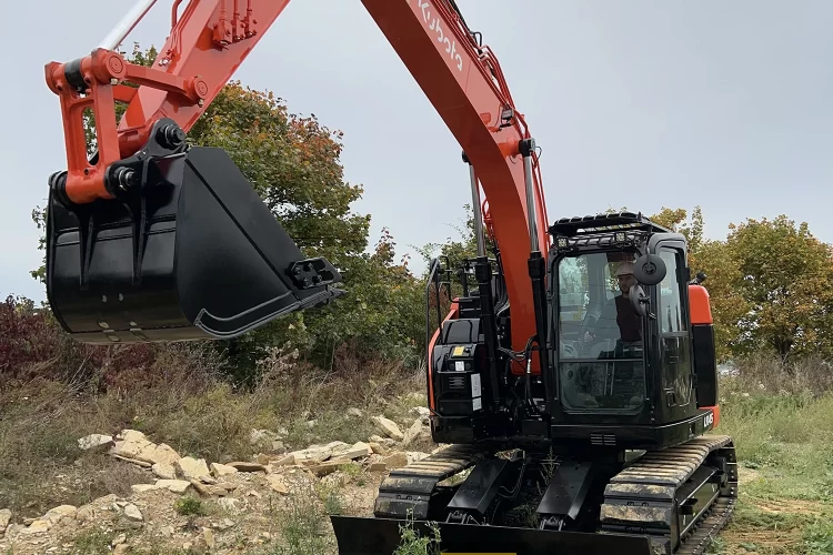 Koparka gąsienicowa Kubota U145 widoczna od przodu pracująca ramieniem